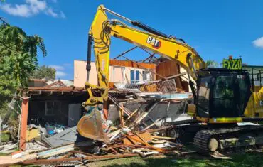 CAT excavator demolishing a house